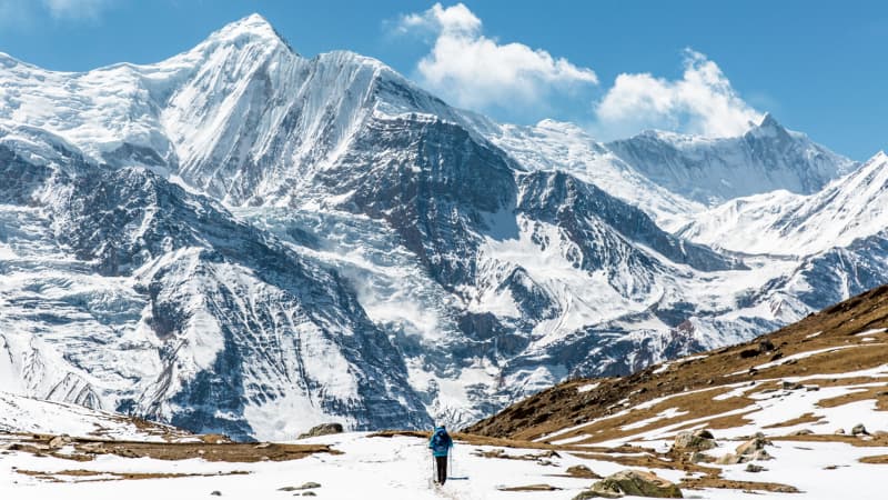 Profile photo of a trekking guide wearing a blue cap and sunglasses in the mountains